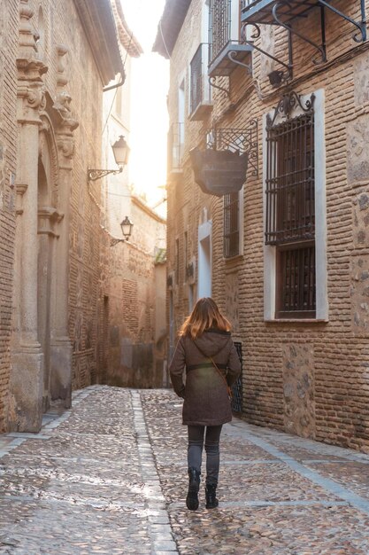 Un turista caminando al atardecer en la ciudad medieval de Toledo en Castilla La Mancha, España