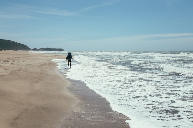 Foto turista caminando por la playa