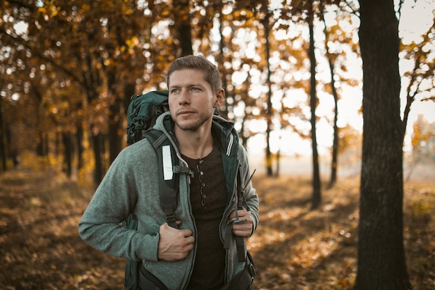 Turista caminando por un sendero del bosque en otoño