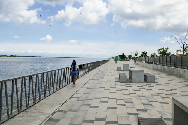 Turista caminhando ao longo do passeio e do rio Magdalena Barranquilla Colômbia