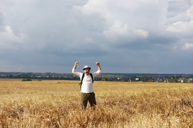 Turista en un campo de plantas de cereales. Un hombre en un campo de trigo. Cosecha de granos.