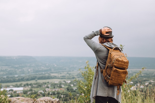 Turista carregando uma mochila grande e caminhando para as montanhas