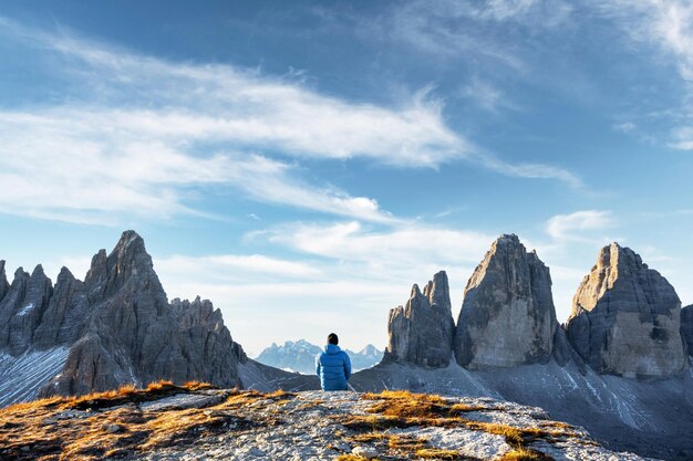 Turista con chaqueta azul en la pista Three Peaks of Lavaredo en la temporada de otoño