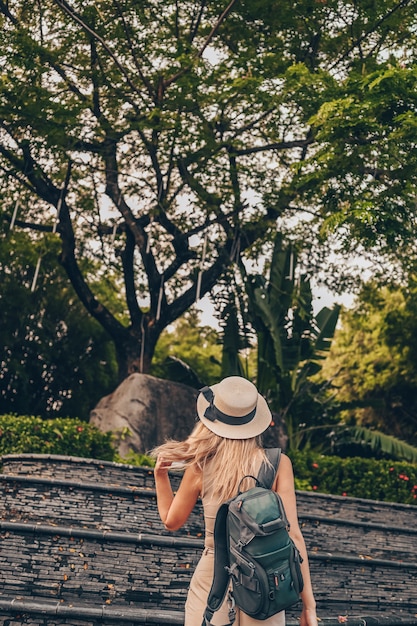 Turista chinês andando e descobrindo a natureza no turismo de férias na Ásia. Mulher bonita caucasiana no chapéu com mochila. Conceito de estilo de vida de viagens. Sanya, Hainan, China