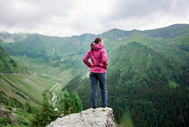 Turista en la cima de la colina en las montañas