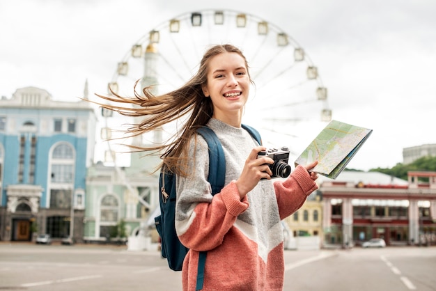 Foto turista en la ciudad y noria detrás