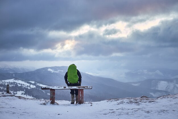 Turista com mochila e panorama da montanha. paisagem de inverno. caminhada