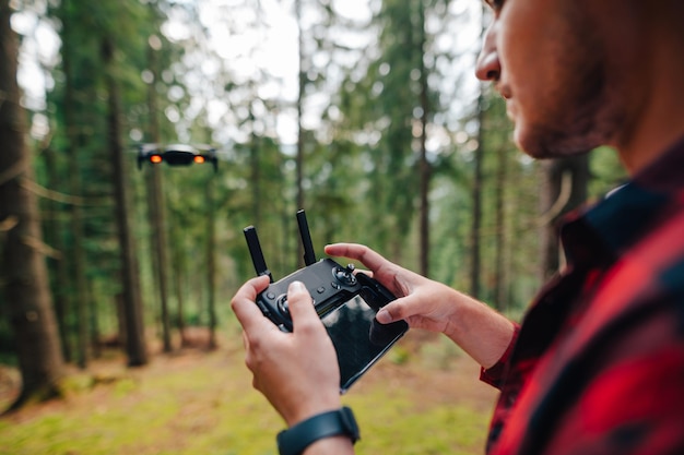 Turista controla el dron desde el control remoto con un teléfono inteligente