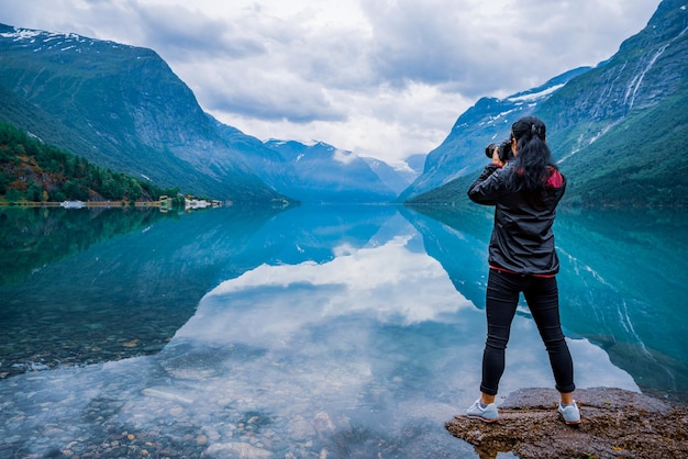 Turista de fotógrafo de natureza com câmera atira paisagem natural bela natureza Noruega. lago lovatnet.