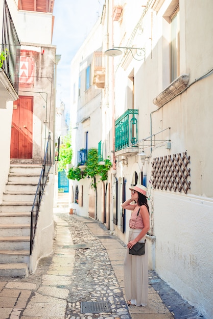 Turista de garota caminha ao ar livre em rua estreita