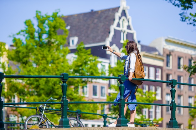 Turista de jovem mulher tirando foto de selfie de auto-retrato na Europa viajar na cidade de Amsterdã