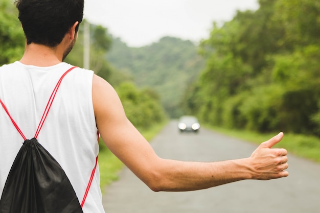 Turista de mochileiro pedindo carona na estrada da montanha no vietnã