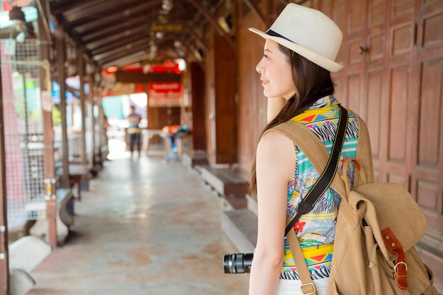 turista de mulher andando nas ruas comerciais de cultura da loja de portas de madeira na cidade de Hong Kong. jovem turista feminina fazendo compras na famosa rua do antigo mercado tradicional na Ásia.