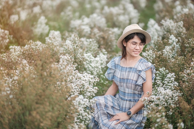 Turista de mulher feliz em vestido azul desfrutar no jardim de flores de Margaret branca. conceito de viagens, natureza, férias e férias