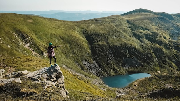 Turista de mulher no fundo das montanhas verdes e lago