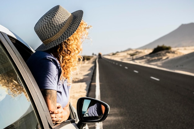 Foto turista desfrutar do sol e do ar livre fora da janela do carro durante uma pausa estacionamento de veículos à beira da estrada e mulheres pessoas admirando a paisagem conceito de viagem e férias de verão