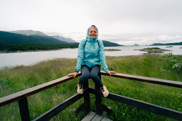 Foto turista em bahia lapataia em meio às montanhas da terra do fogo