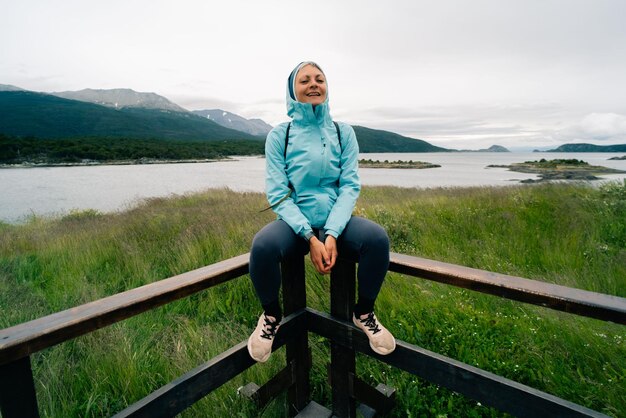 Foto turista em bahia lapataia em meio às montanhas da terra do fogo