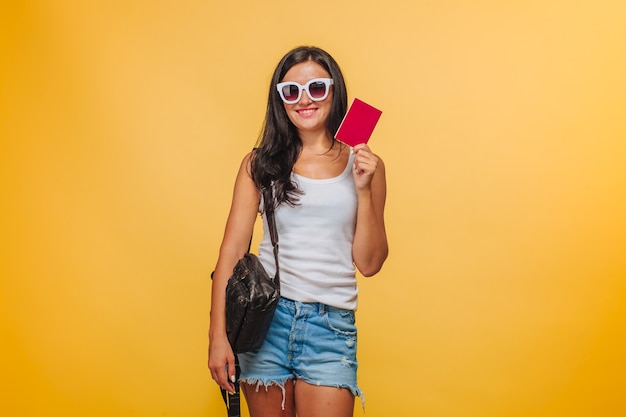 Turista em um fundo amarelo com uma mochila e um passaporte