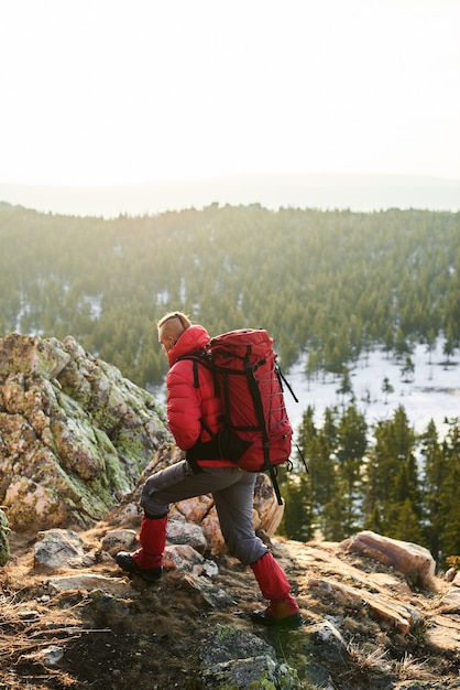 El turista está en la cima de la montaña de piedra.