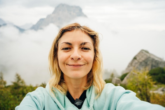 un turista se está tomando una selfie de la vista del monte Civetta en las Dolonitas, Italia