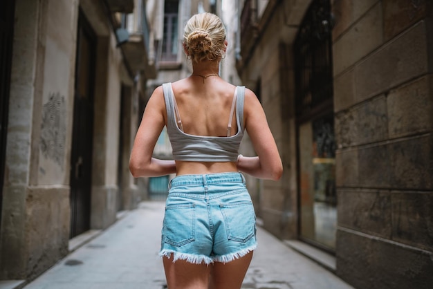 Turista feliz caminando hacia atrás en el callejón del casco antiguo Barcelona España