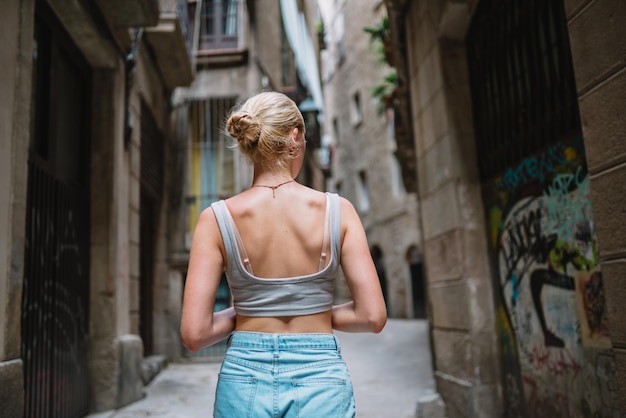 Turista feliz caminando hacia atrás en el callejón del casco antiguo Barcelona España