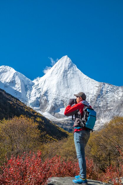 Turista feliz en la cima de la montaña con mochila