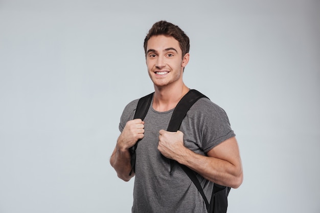 Turista feliz e alegre com mochila isolada no branco