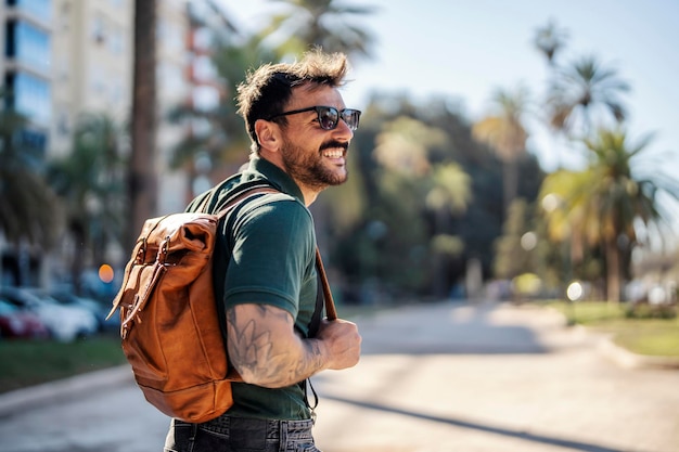 Un turista feliz está caminando en el centro de la calle tropical city39s