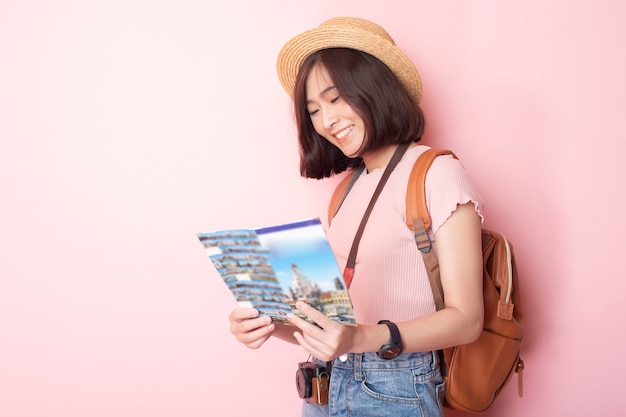 Turista feliz mulher asiática na parede rosa