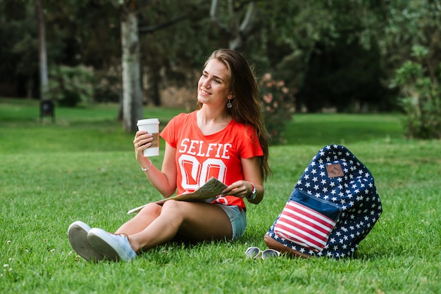 Turista femenino feliz que se relaja en el parque