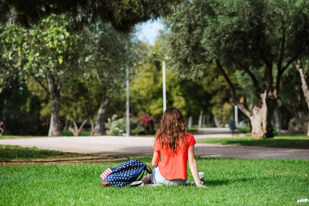 Foto turista femenino feliz que se relaja en el parque