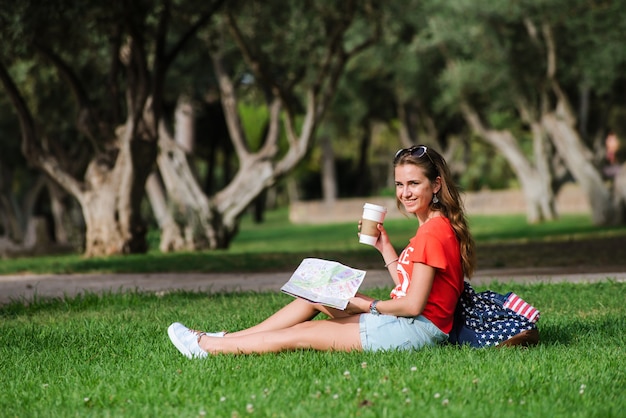 Turista femenino feliz que se relaja en el parque