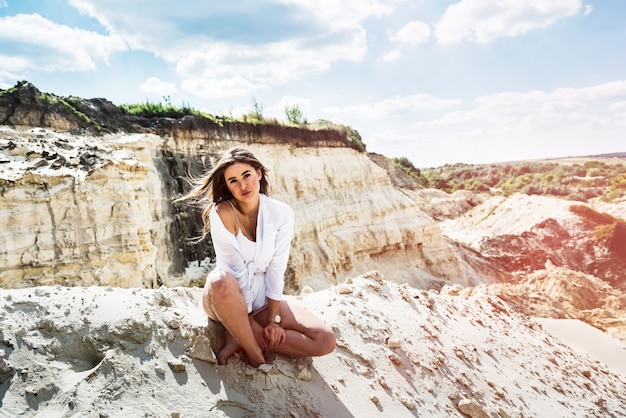 Turista feminina sentar e relaxar após um dia difícil na caixa de areia, canyon. férias em um dia quente sunnt. liberdade