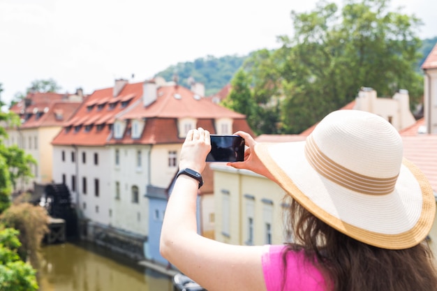 Foto turista feminina tirando uma foto com o telefone celular.