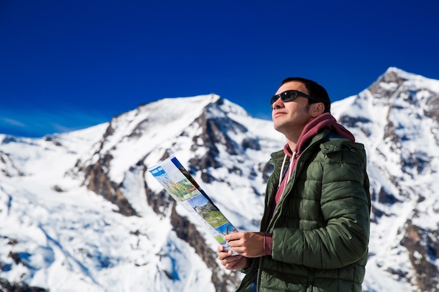 Turista en el fondo de montañas nevadas