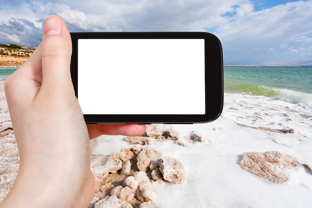 Turista fotografa litoral de sal do Mar Morto