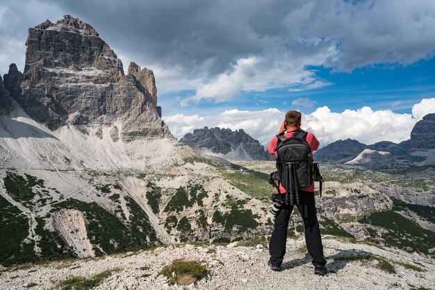 Turista de fotógrafo de la naturaleza con disparos de cámara mientras está de pie Alpes Dolomitas de Italia.
