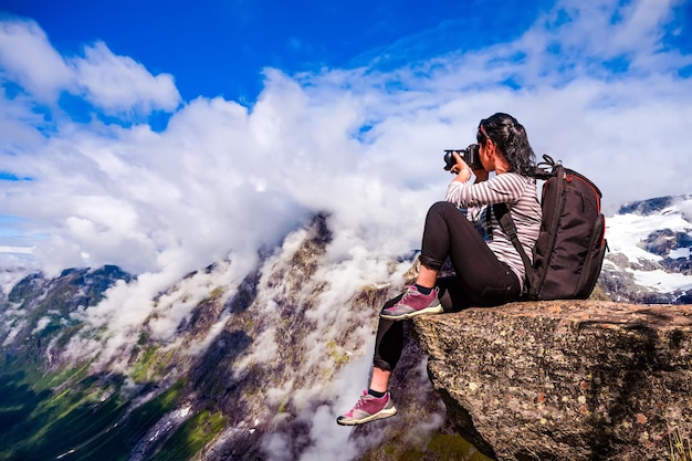 Turista fotógrafo de la naturaleza con tomas de cámara mientras está de pie en la cima de la montaña. Hermosa Naturaleza Noruega.