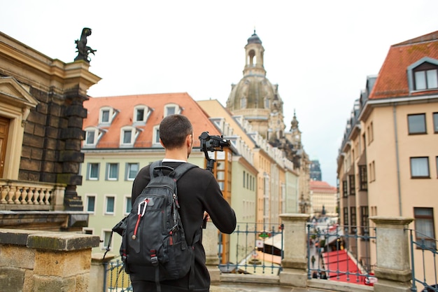 Turista graba un video con un gimbal en la calle de la ciudad