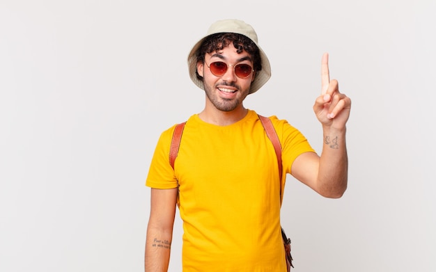 Turista hispano que se siente como un genio feliz y emocionado después de darse cuenta de una idea, levantando alegremente el dedo, ¡eureka!