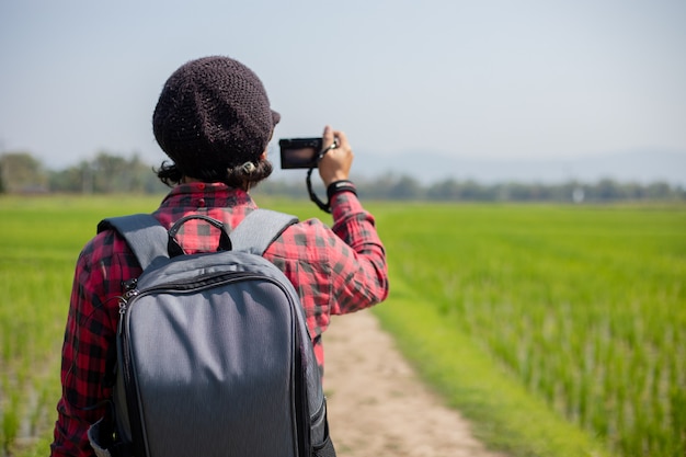 Turista hombre asiático está utilizando una cámara para tomar fotos de paisajes y montañas. Tiempo de relajación en viajes concepto de vacaciones