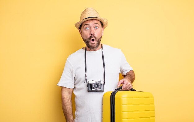 Turista de hombre de mediana edad que parece muy sorprendido o sorprendido. concepto de viaje