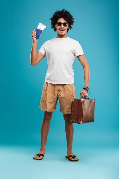 Turista de hombre rizado africano joven feliz guapo