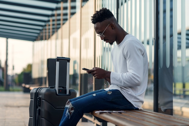 Turista jovem barbudo com mochila e smartphone