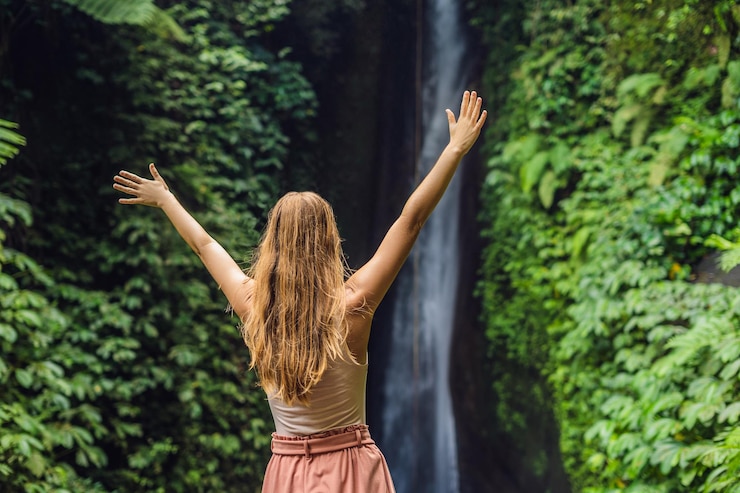 Foto turista jovem no fundo da cachoeira leke leke na ilha de bali indonésia
