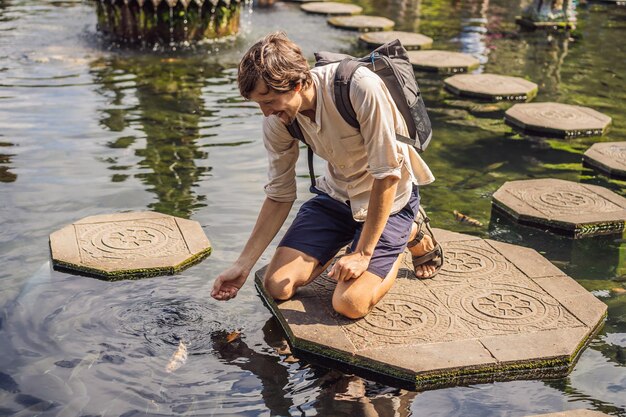 Turista jovem no palácio aquático Taman Tirtagangga Parque aquático Bali Indonésia