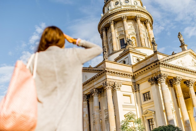 Turista jovem olhando para a Igreja francesa na cidade de Berlim. Imagem com foco no fundo