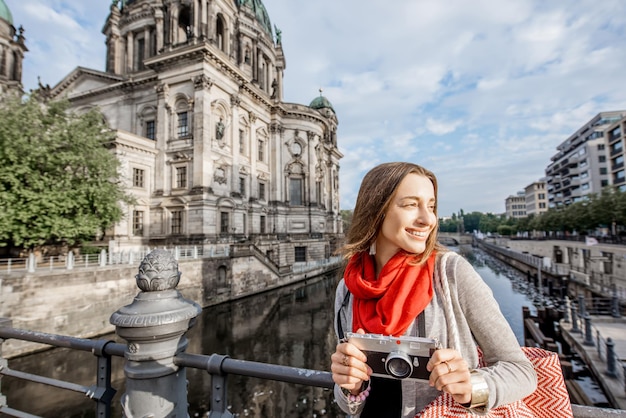 Turista joven con cámara de fotos disfrutando de viajar en la ciudad de Berlín caminando cerca de la famosa catedral